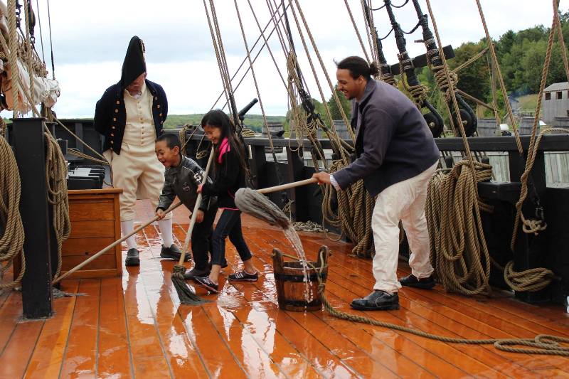 Swabbing the deck of the H.M.S. Bee at Discovery Harbour, Penetanguishene