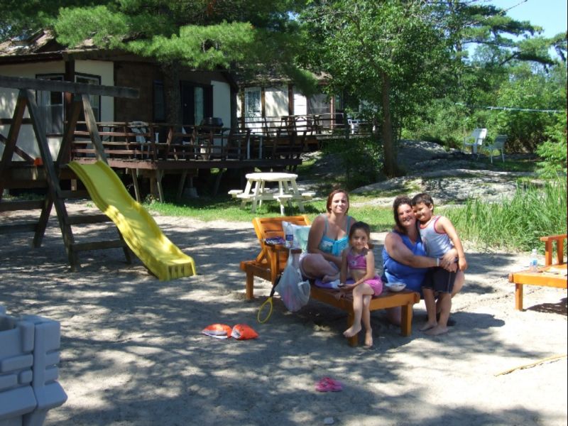 Family on Elm Cove beach; cottages #3 & #2 behind